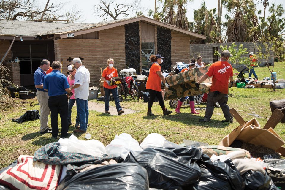 Billy Graham Rapid Response Team chaplains praying with homeowners; Samaritan's Purse volunteers moving furniture from home