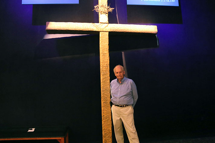 Man standing in front of a cross.