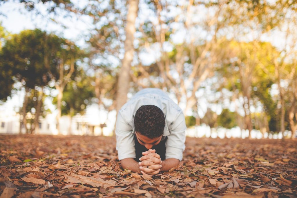 man praying in fall forest