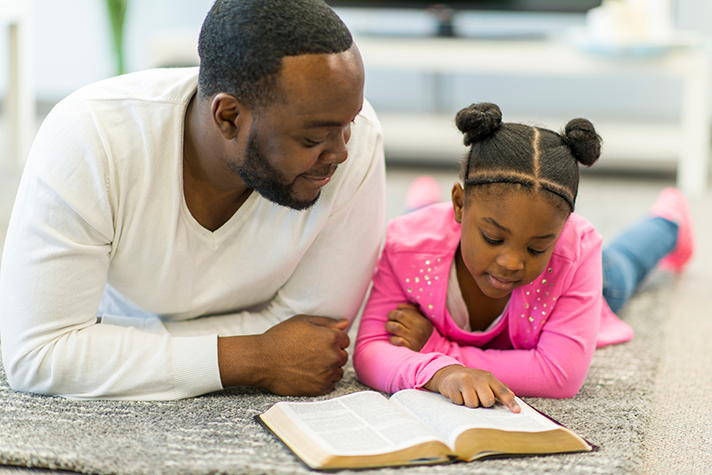 father and daughter reading Bible