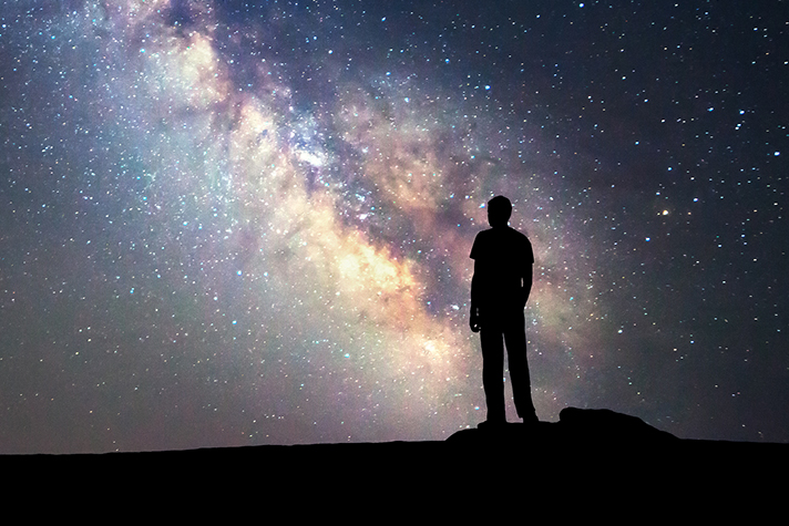 Milky Way. Night sky and silhouette of a standing man