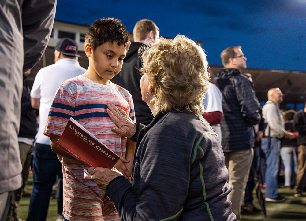 woman praying with little boy