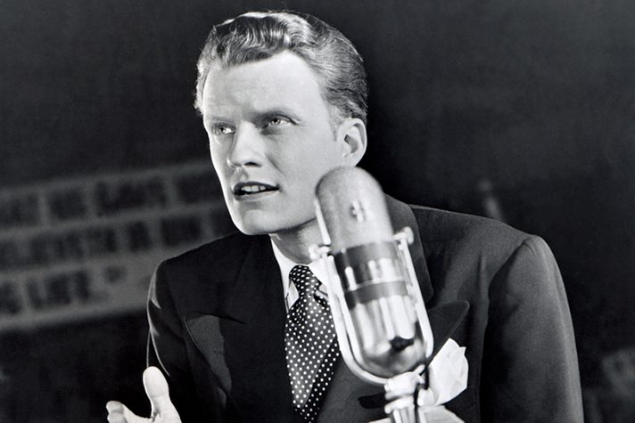 Billy Graham speaking into a microphone