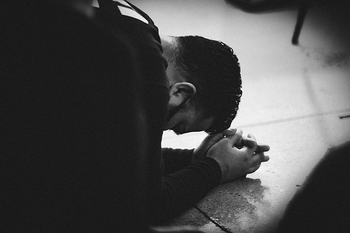 Man bowed to the ground praying