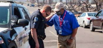 Chaplain praying with police officer after tornado