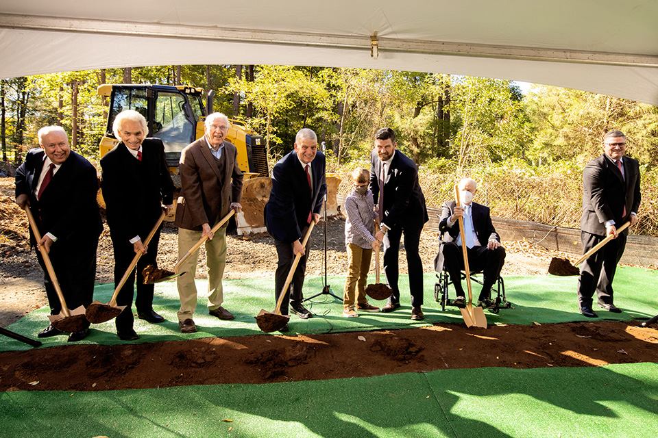 Men holding shovels, smiling, at groundbreaking