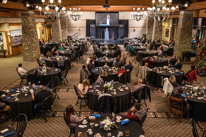 Tables of spread out people inside large room