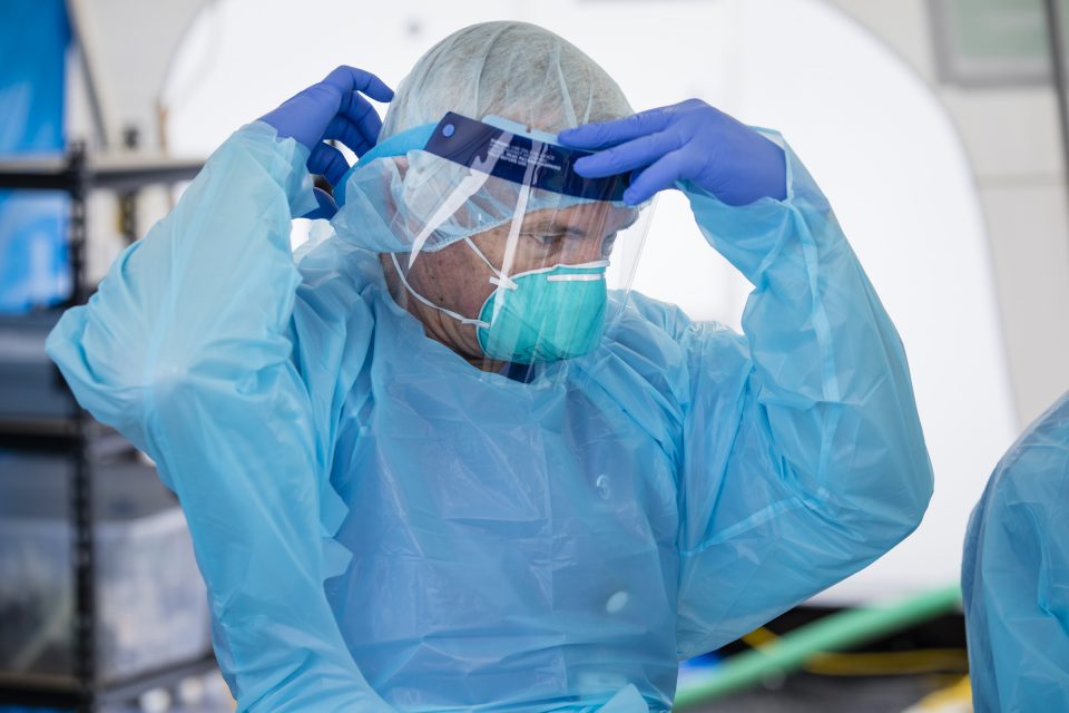 Medical staff adjusting face shield