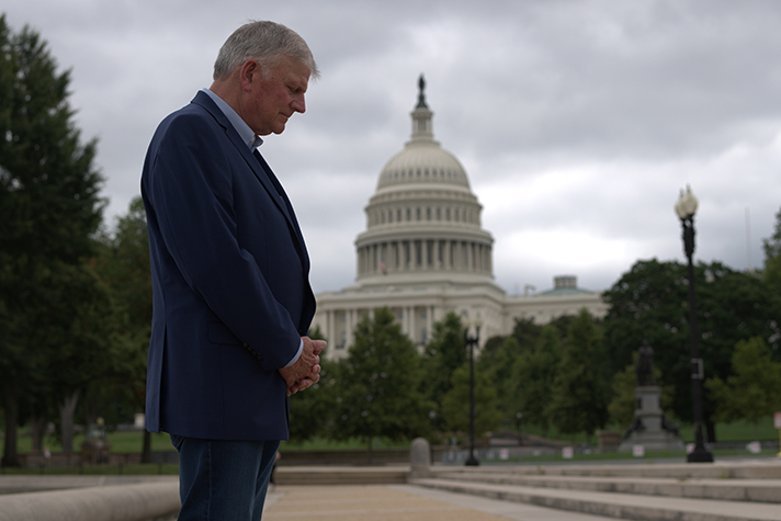 Franklin Graham prays with U.S. Capitol in background