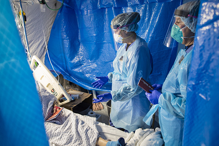 chaplains wearing PPE in tent hospital