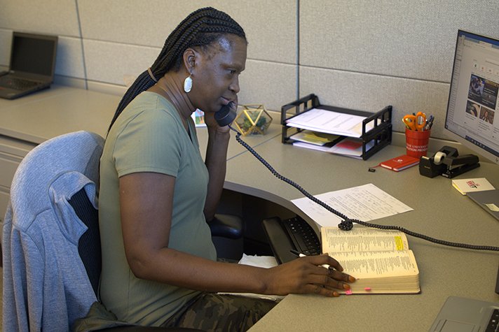 Prayer line representative listening on phone