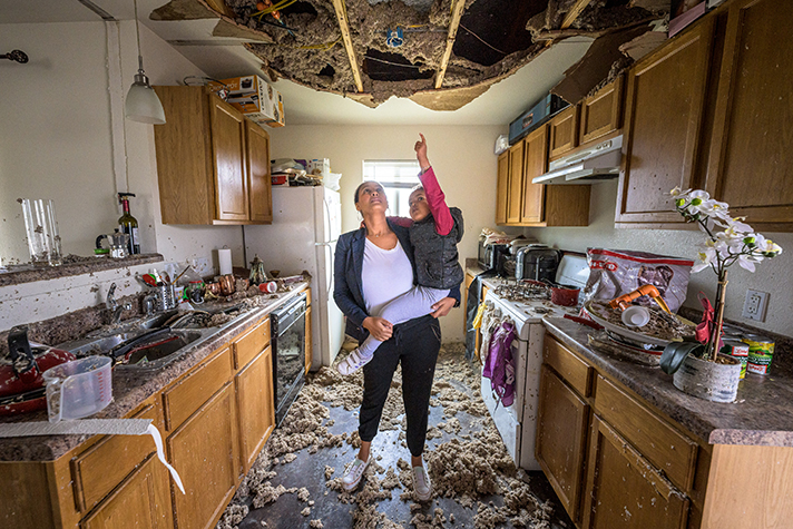 woman holding child in destroyed kitchen