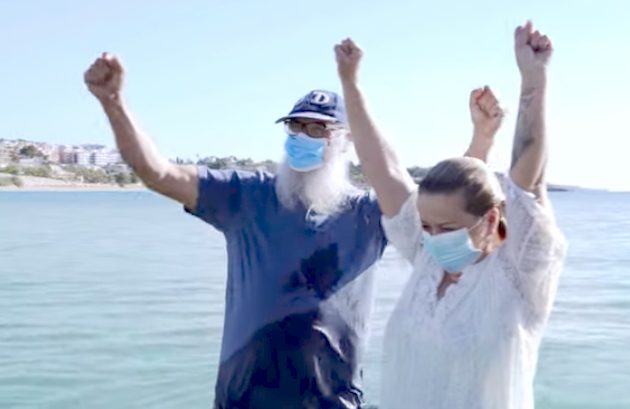 Pastor Salvori and Ana María stand in water, arms in air, after her baptism