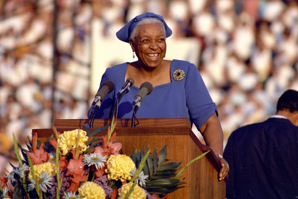 Ethel Waters smiling at lectern, crowd behind her