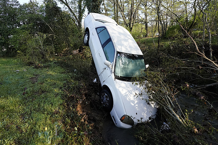 White car hood first into ditch