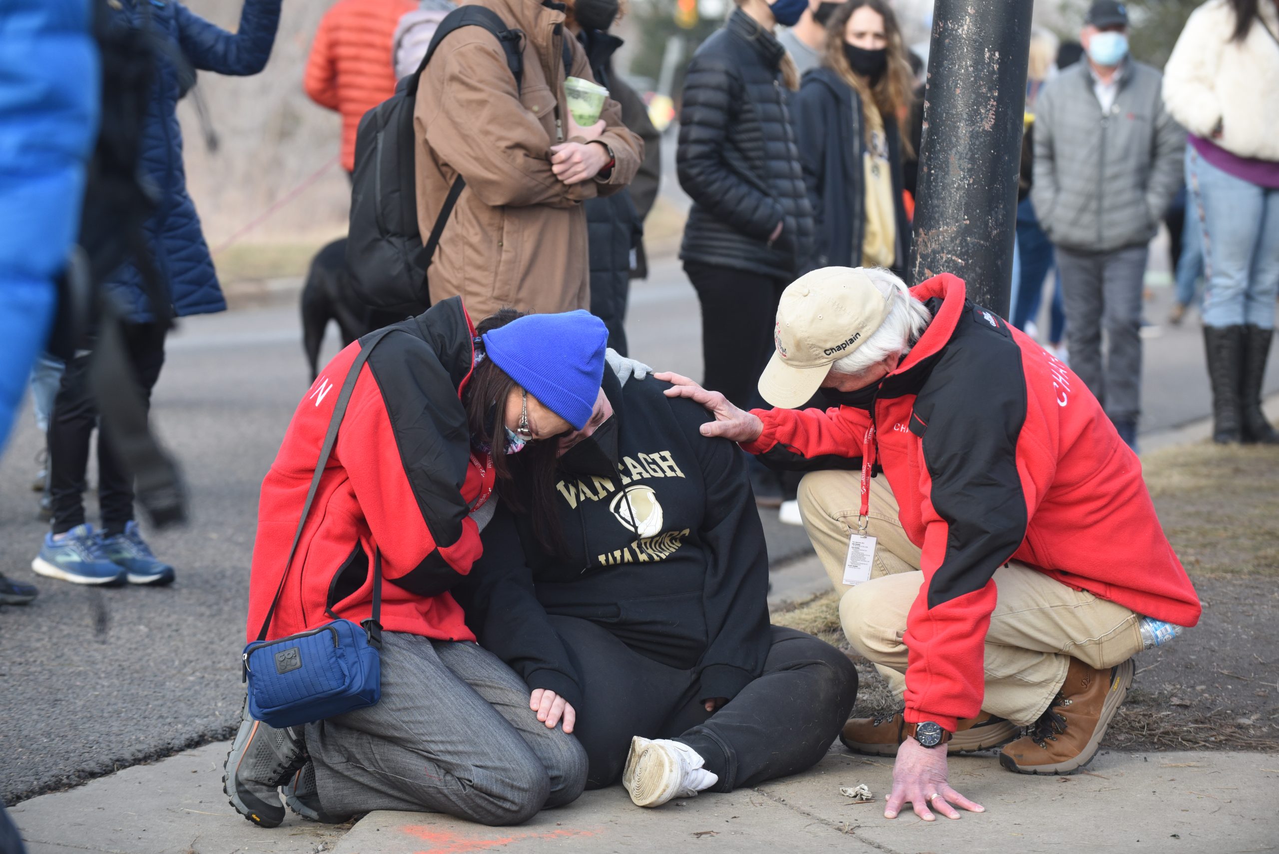 Chaplains surround and comfort a local who's weeping 