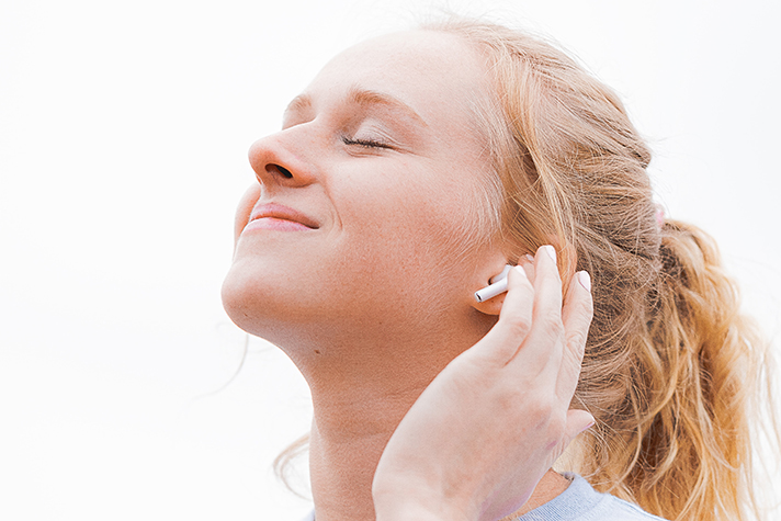 Woman with wireless, earbuds listening