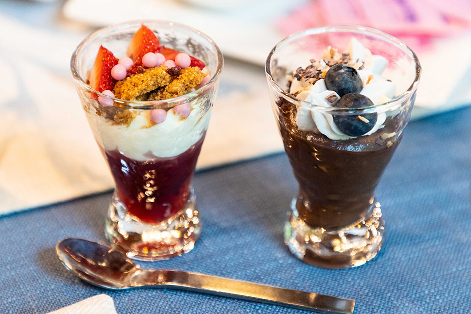 Two small glasses, each with a different dessert