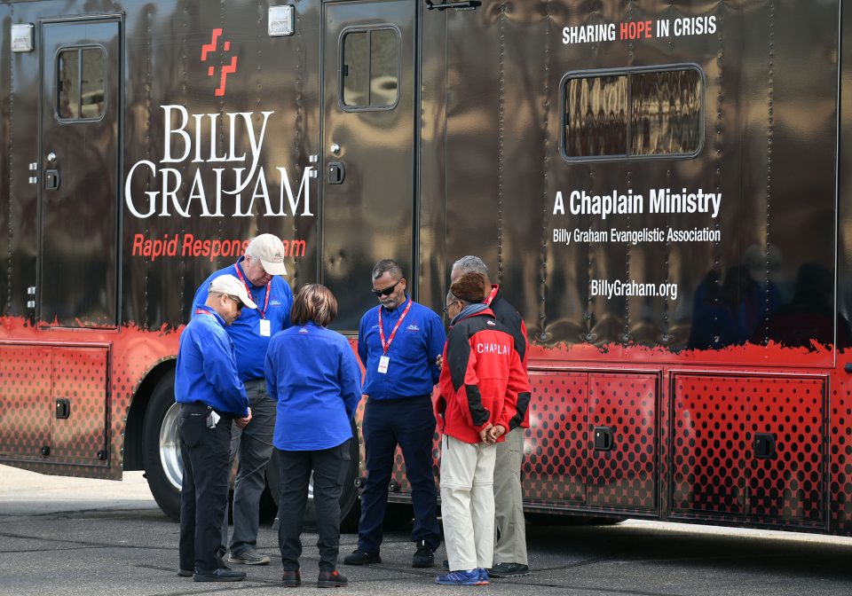 Chaplains praying in front of the Rapid Response Team's Mobile Ministry Center