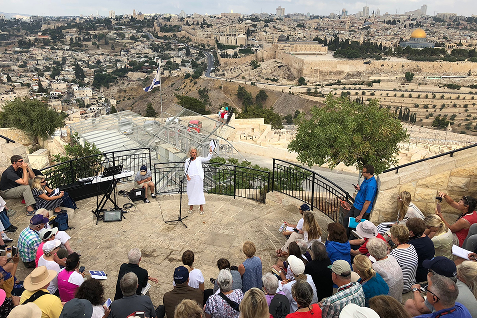 Anne Graham Lotz overlooking Jerusalem, holding up a Bible