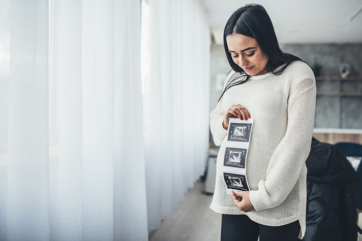 Pregnant woman holding her baby sonography