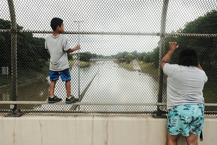 woman and child looking at flooded highway