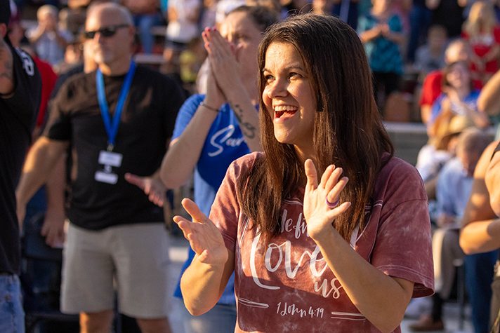 Woman in crowd clapping hands