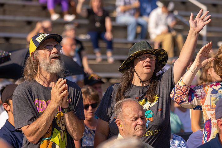 Man and woman worshiping in crowd