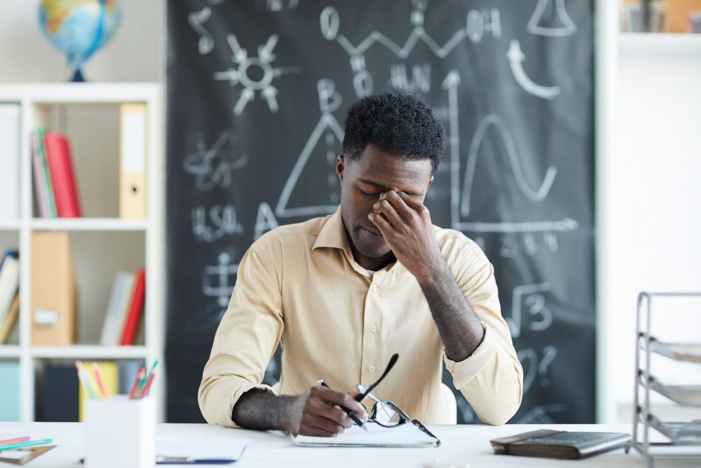 Teacher holding his hand to his head