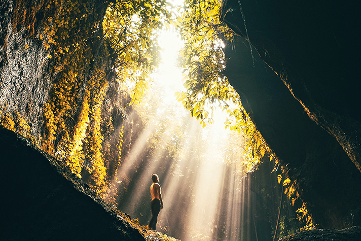 Person looking up at rays of light streaming