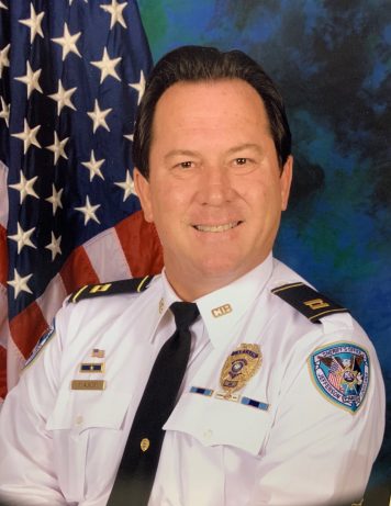 Officer Michael Alwert with flag in background