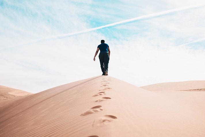 man walking in desert