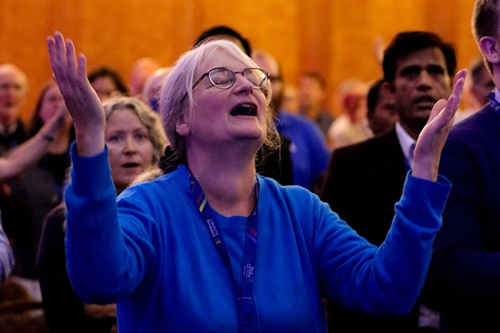 woman singing with hands raised