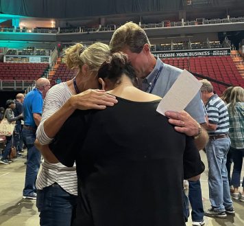 woman praying with counselors