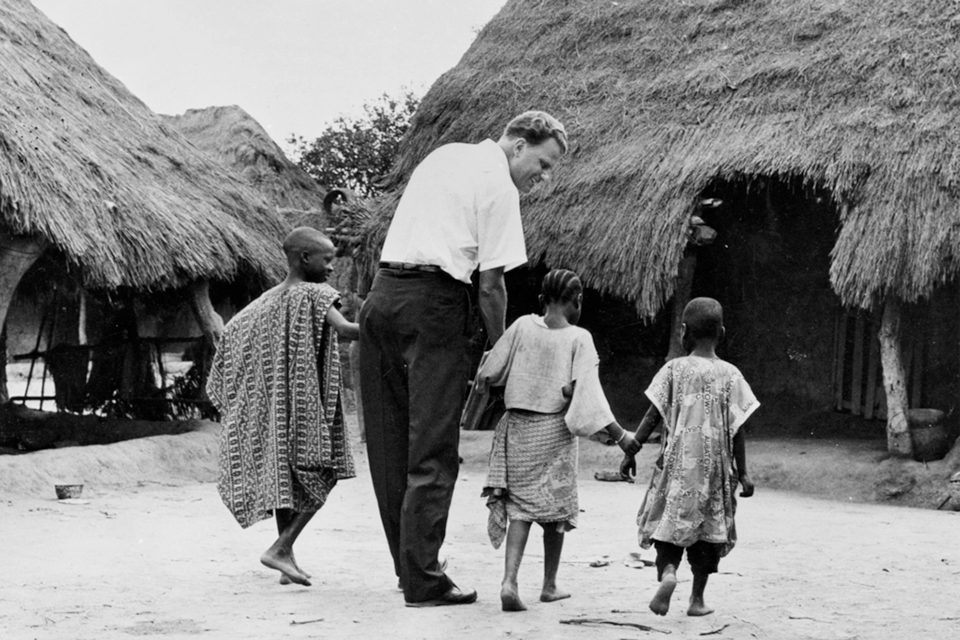 Billy Graham holding hands with children