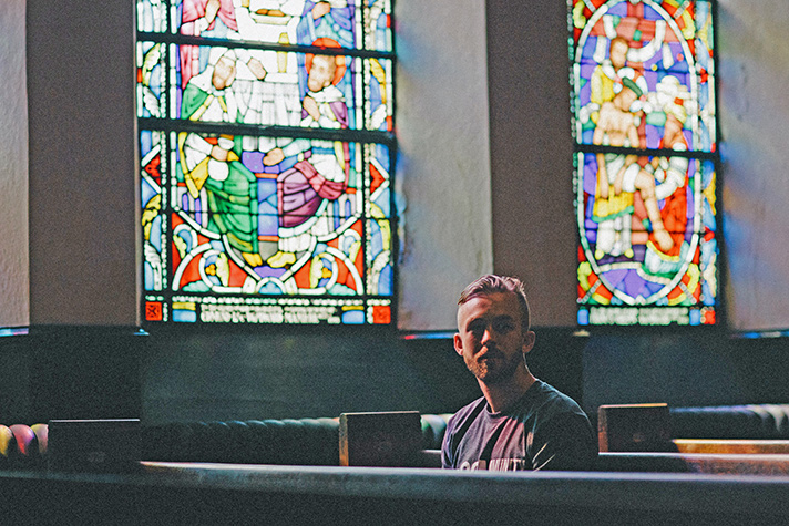man sitting in church pew