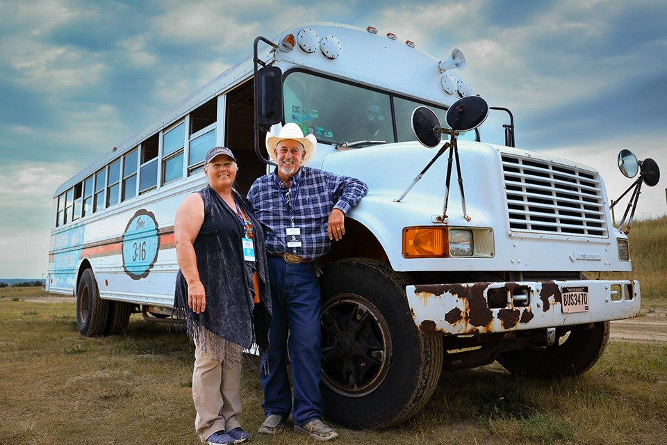 man and wife stand by bus