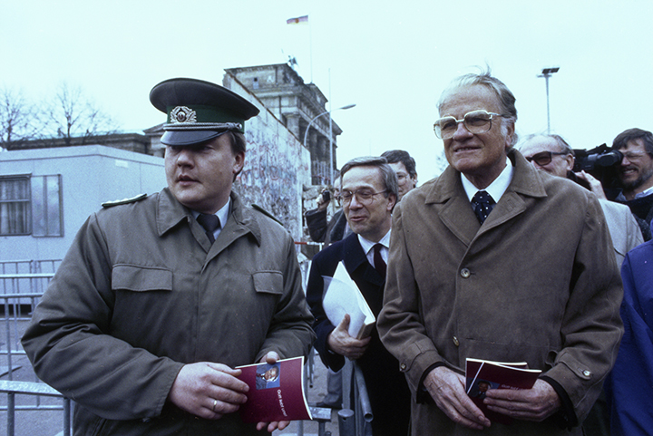 An East German officer walks with Billy Graham near the Brandenburg Gate on March 10, 1990 - four months after the opening of the Berlin Wall.