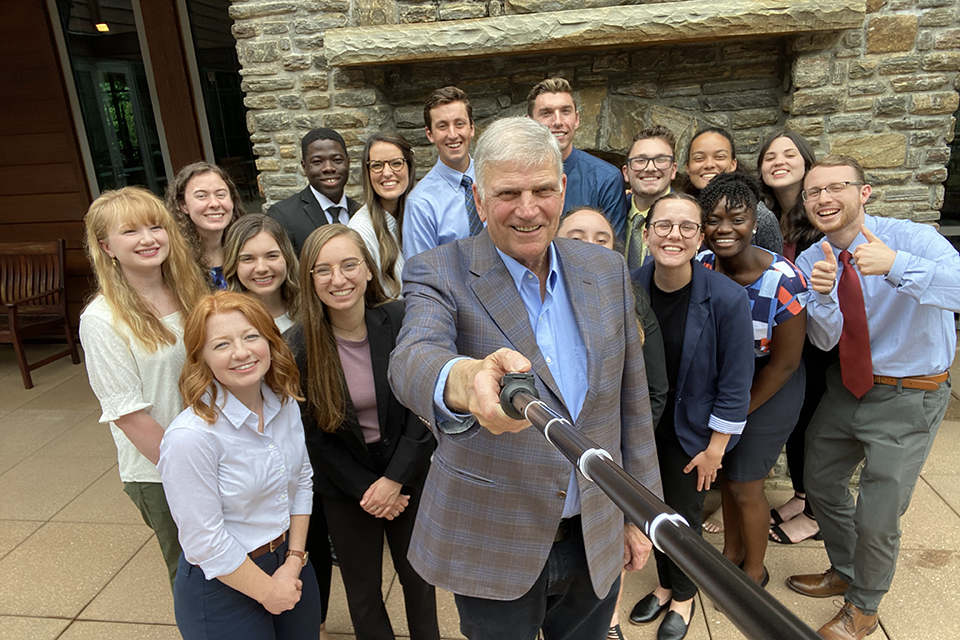 Interns posing with a picture with Franklin Graham