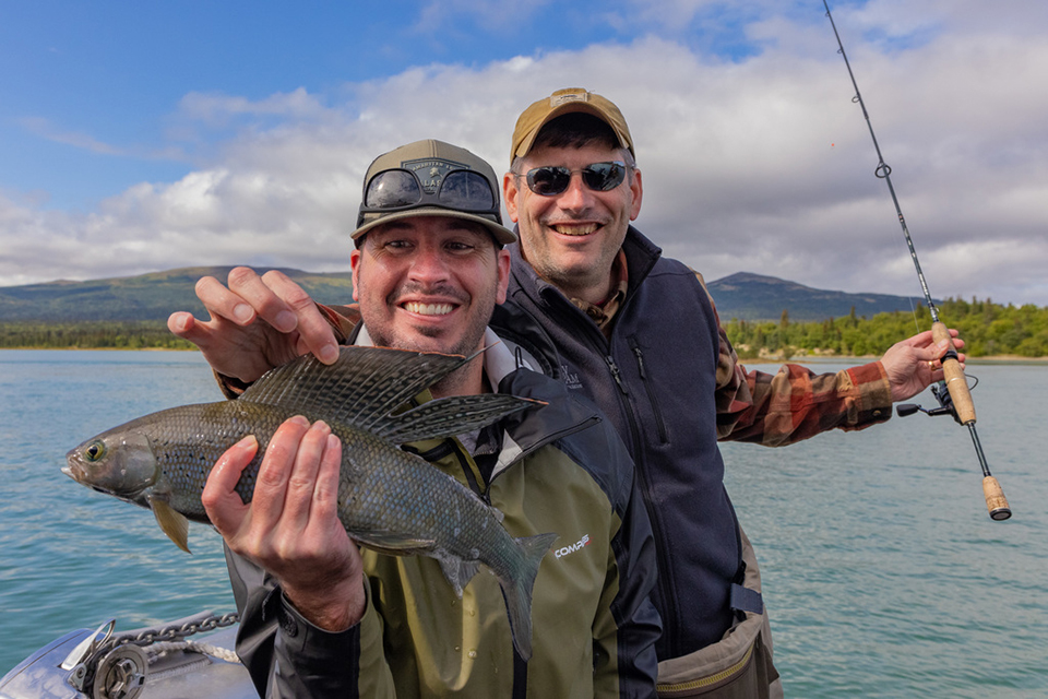 Will Graham with man catching a fish in Alaska