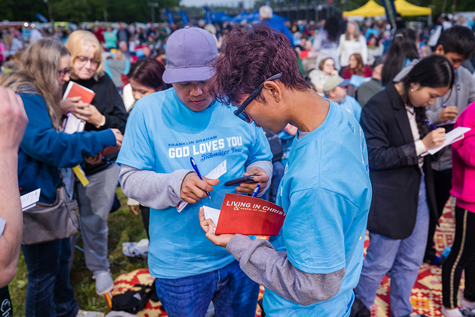 Prayer team volunteer handing out resources to new believer.