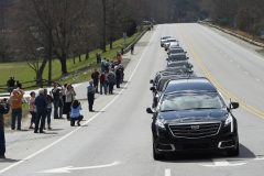 People line the street as the hearse carrying the body of Rev. Billy Graham leaves the Billy Graham Training Center at the Cove on Saturday, Feb. 24, 2018 in Asheville, N.C. Graham's body will be brought to his hometown of Charlotte on Saturday, Feb. 24, as part of a procession expected to draw crowds of well-wishers. (AP Photo/Kathy Kmonicek, Pool)