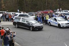 The hearse carrying the body of Billy Graham drives past people as it arrives at the Billy Graham Library in Charlotte, N.C., Saturday, Feb. 24, 2018. Graham's body was brought to his hometown of Charlotte on Saturday, Feb. 24, as part of a procession expected to draw crowds of well-wishers. (AP Photo/Kathy Kmonicek, Pool)
