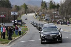 People line the street to pay respects as the hearse carrying the body of Rev. Billy Graham travels past Black Mountain, N.C., Saturday, Feb. 24, 2018. (AP Photo/Kathy Kmonicek, Pool)