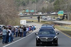 People watch as the hearse carrying the body of Billy Graham leaves Hickory, N.C., as it drives toward the Billy Graham Library Saturday, Feb. 24, 2018. Graham's body was brought to his hometown of Charlotte on Saturday, Feb. 24, as part of a procession expected to draw crowds of well-wishers. (AP Photo/Kathy Kmonicek, Pool)