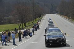 People watch as the hearse carrying the body of Billy Graham leaves Asheville, N.C., Saturday, Feb. 24, 2018. Graham's body was brought to his hometown of Charlotte on Saturday, Feb. 24, as part of a procession expected to draw crowds of well-wishers. (AP Photo/Kathy Kmonicek)