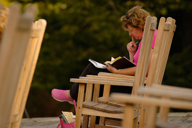 Woman on rocking chair reading bible